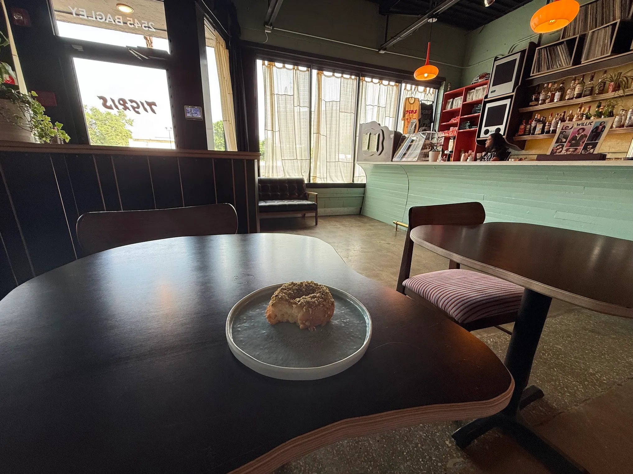 A pistachio-crumb donut on a plate at Tigris during the day